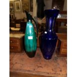 A tall blue glass vase and a pottery jug