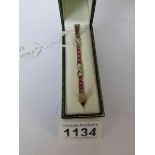 A 9ct gold bracelet with channel set diamonds and pink stones