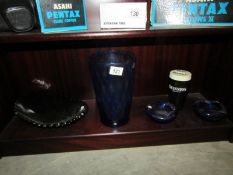 A collection of blue glass items and a Guinness money box