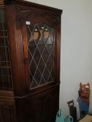 An oak lead glazed corner cabinet