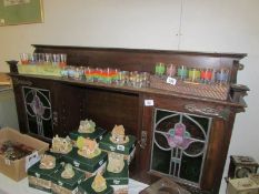 A dresser top with art nouveau glass doors and with key