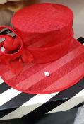 A large red hat with a black and white hat box
