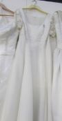 A cream scoop neck wedding gown with bead detail on sleeves and bodice,