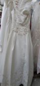 An ivory 'Mon Cheri Inc' bridal gown, fitted at waist with full skirt and applique' floral design,