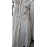 An ivory 'Mon Cheri Inc' bridal gown, fitted at waist with full skirt and applique' floral design,