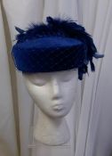 A blue pill box hat with decorative feather detail