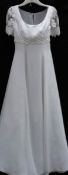 A white empire line gown with lace bodice and sleeves,