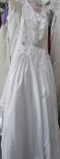 A white 'Mon Cheri Bridals Inc' wedding gown with decorative embroidered fitted bodice and full