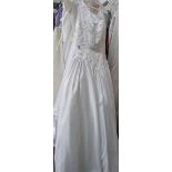 A white 'Mon Cheri Bridals Inc' wedding gown with decorative embroidered fitted bodice and full