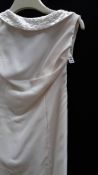 An ivory slim fit gown with beaded decoration to neck line,