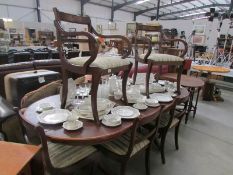 A mahogany extending dining table with protective cover and a set of 8 brass inlaid dining chairs
