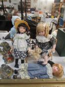 A small doll's pram and 4 porcelain dolls