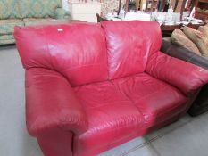 A red leather 2 seat sofa