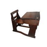 An Edwardian oak child's desk with combined folding chair and ceramic castors,