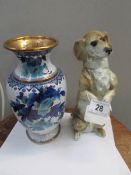 A Capo-di-monte ceramic dachsund with fitting for light and an enamel vase