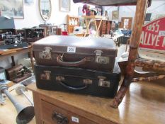 A vintage leather suitcase and one other
