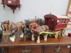A shire horse pulling gypsy caravan and a shire horse pulling cart