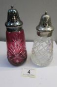 A cranberry glass sugar sifter and a clear glass sugar sifter