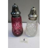 A cranberry glass sugar sifter and a clear glass sugar sifter