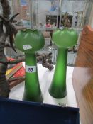 A pair of tall green glass vases