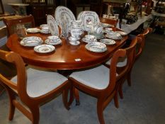 A good quality extending dining table and 6 chairs in pale mahogany