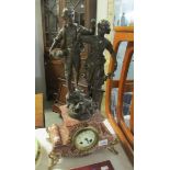 A French mantel clock surmounted pair of figures