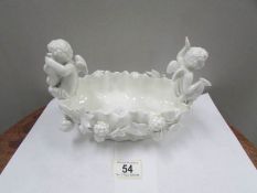 A 19th century hard paste bowl surmounted cherubs