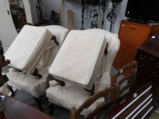 A pair of wing armchairs with matching stools