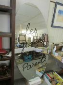 A large oval unframed ship mirror with lettering