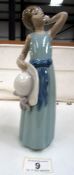 A Lladro figurine of a girl holding a hat