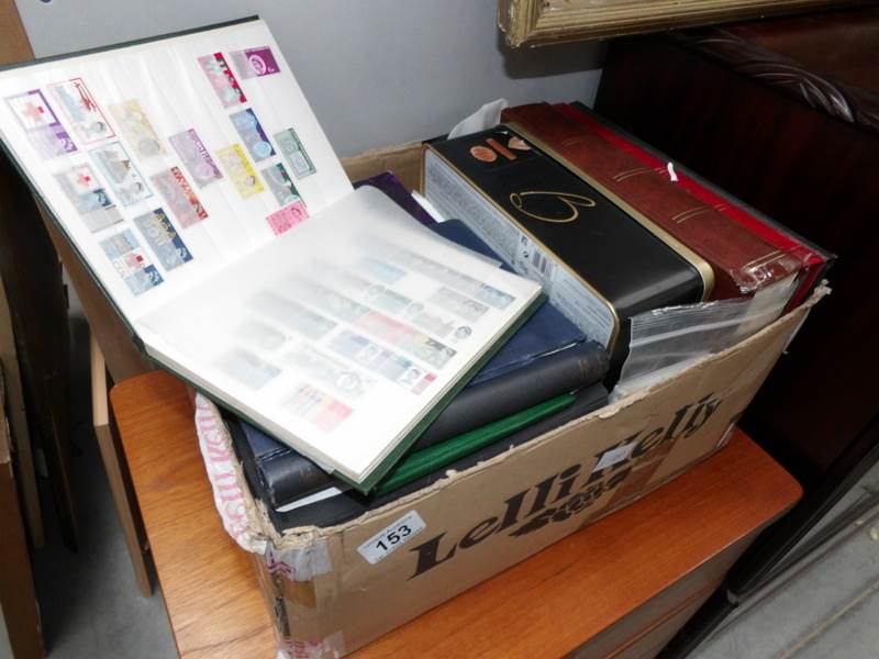 A box of tins and albums of stamps and first day covers