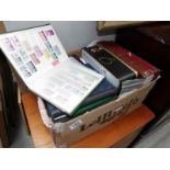 A box of tins and albums of stamps and first day covers