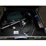 An Accuson dial sphygmomanometer urinometer, A thermometer in steel tube, 3 patella hammers,