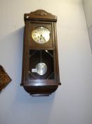An Edwardian oak pendulum wall clock in working order