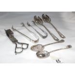 A collection of silver plate sugar tongs, spoons,
