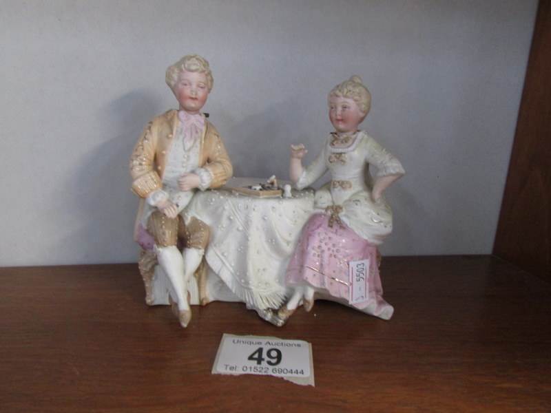 A German bisque porcelain nodding head group of lady and gentleman playing chess (ladies hand is