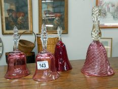 3 cranberry glass bells and a ruby glass bell