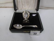 A cased silver egg cup and spoon