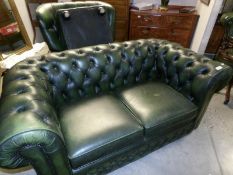 A green leather Chesterfield sofa with matching chair and stool