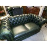 A green leather Chesterfield sofa with matching chair and stool