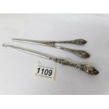 A silver handled button hook and glove stretchers