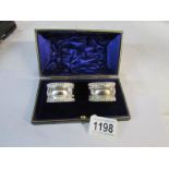 A cased pair of silver napkin rings
