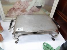 A silver plated hot plate with burner