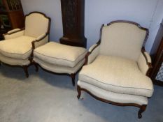 A pair of wood framed armchairs with matching foot stool