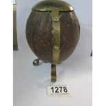 An arts and crafts brass mounted coconut money box