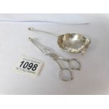 A silver tea strainer and a pair of silver sugar nips