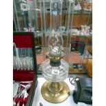 A Victorian oil lamp with brass base and glass font