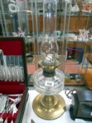 A Victorian oil lamp with brass base and glass font