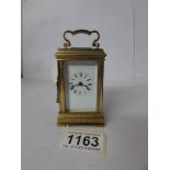 A miniature brass carriage clock with key