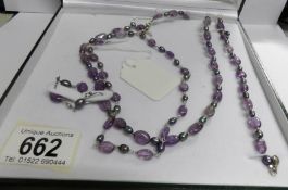 A cased amethyst and pearl necklace with matching bracelet and earrings in silver